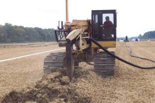Figure 1. Installing perforated plastic drainage tile in an Indiana field (Jason Brown).